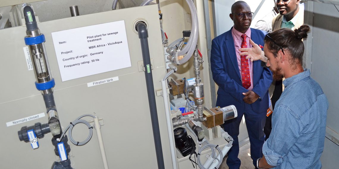 Ephraim Gukelberger (re.), wissenschaftlicher Mitarbeiter der Hochschule Karlsruhe, demonstriert den Membranbioreaktor bei der Inbetriebnahme der Pilotanlage am 23. November 2018 in Kisumu, Kenia. Bild: Jan Hoinkis